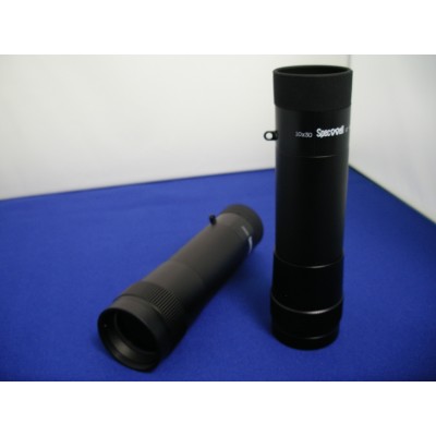 A black Specwell 10x30 spotting scope shown, resting on a blue surface against a white background.