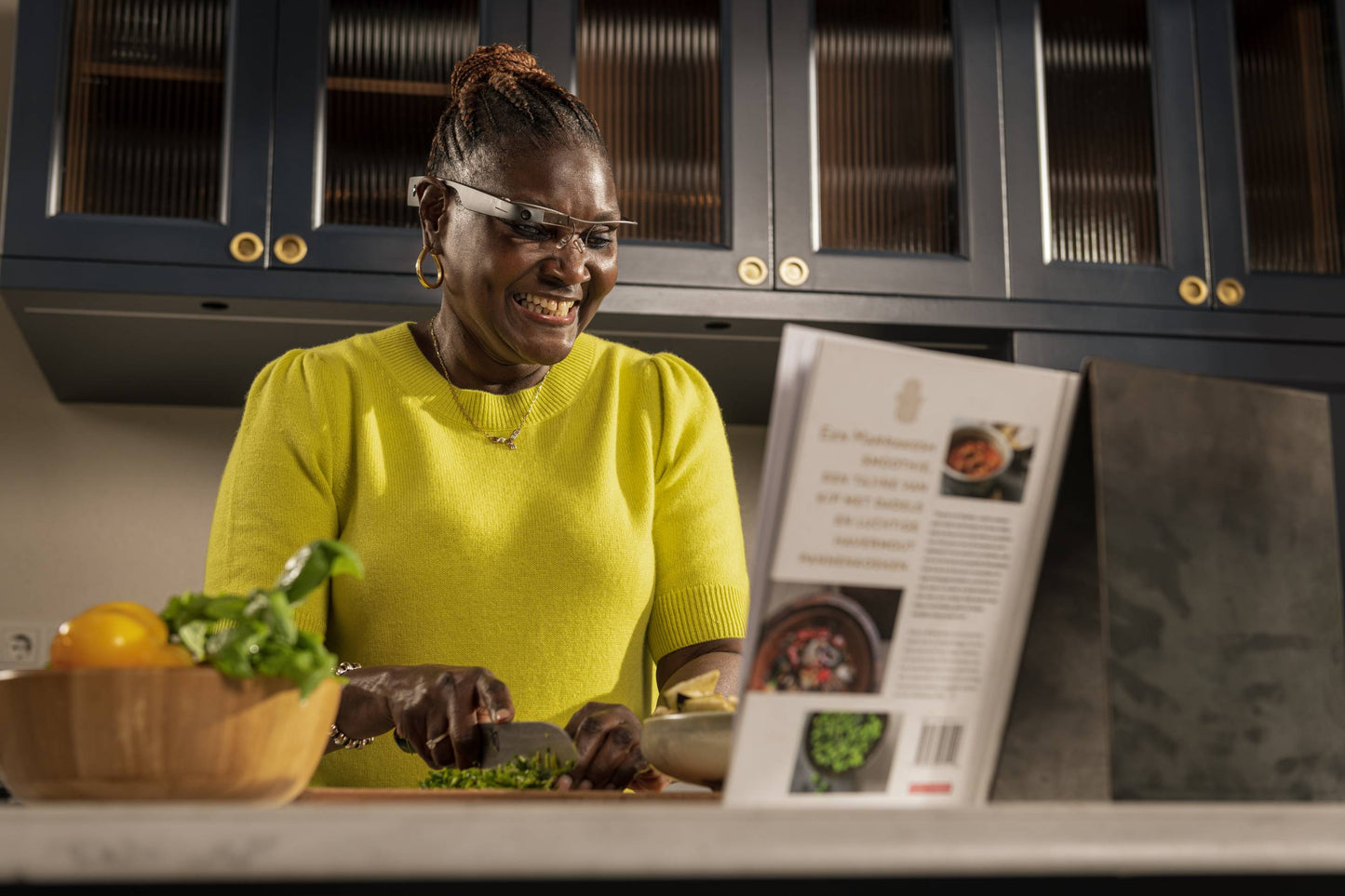A woman wearing envision glasses while cooking in a kitchen
