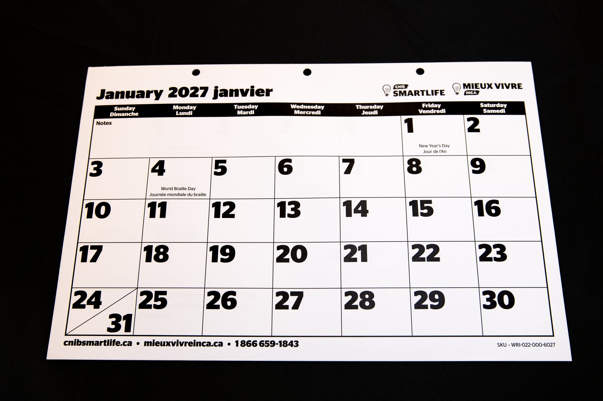 A 2027  CNIB SmartLife Calendar in French and English, photographed against a black background. 