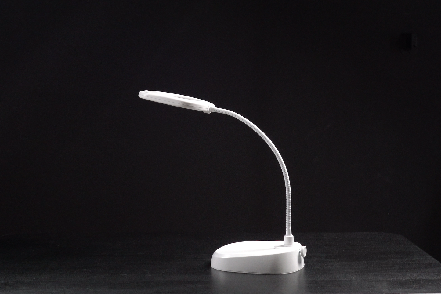 White LED desk lamp on a black background