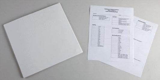 A closed white binder beside printed lesson-monitoring sheets containing tables and assessment information.