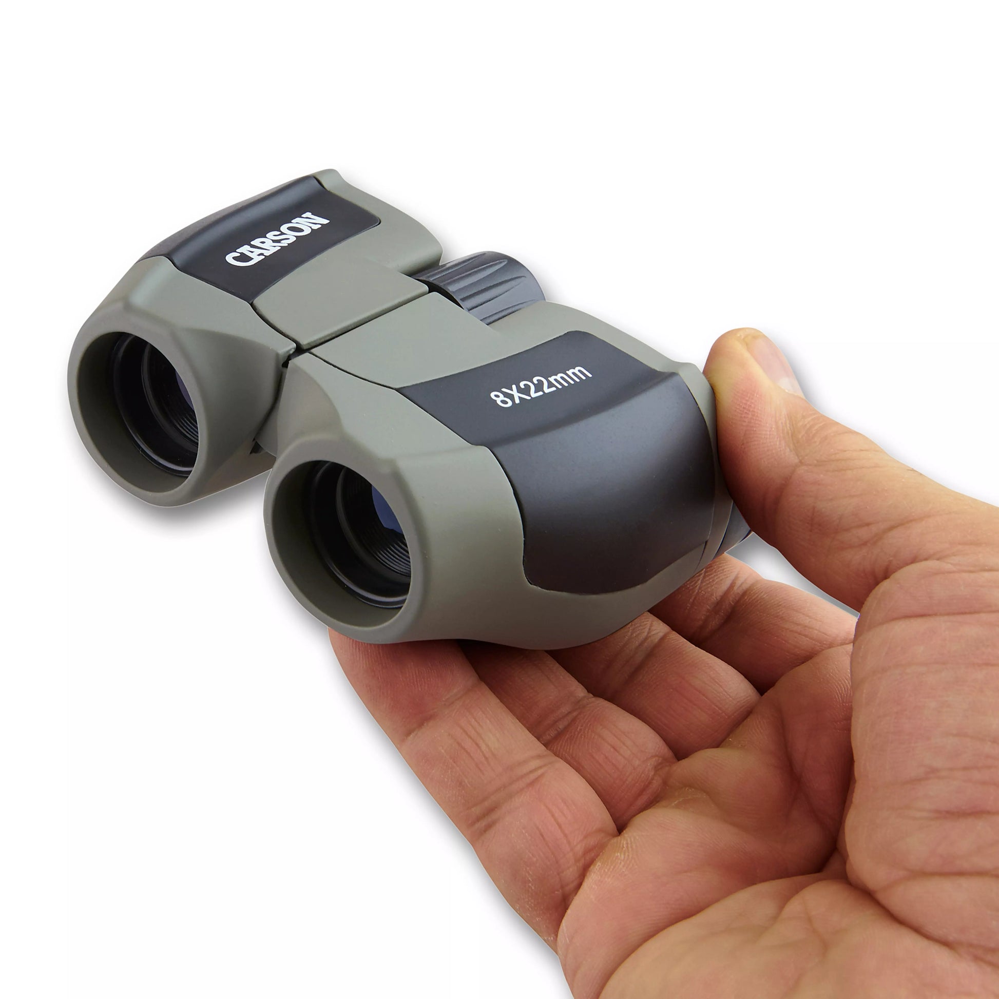 Hand holding Carson Scout binoculars with a white background